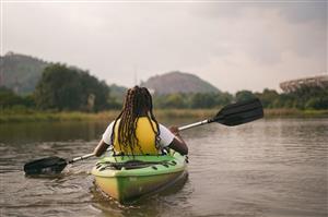Solo Woman Kayaking On The Lake