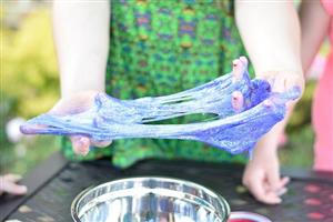 Kids playing with glittery purple slime.